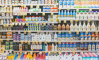 Assorted dairy products on shelves in supermarket aisle